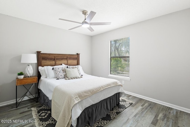 bedroom featuring a ceiling fan, baseboards, and wood finished floors