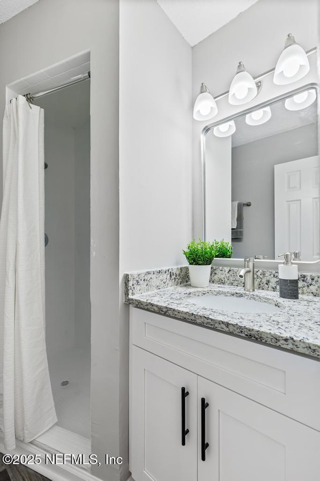 bathroom with curtained shower and vanity