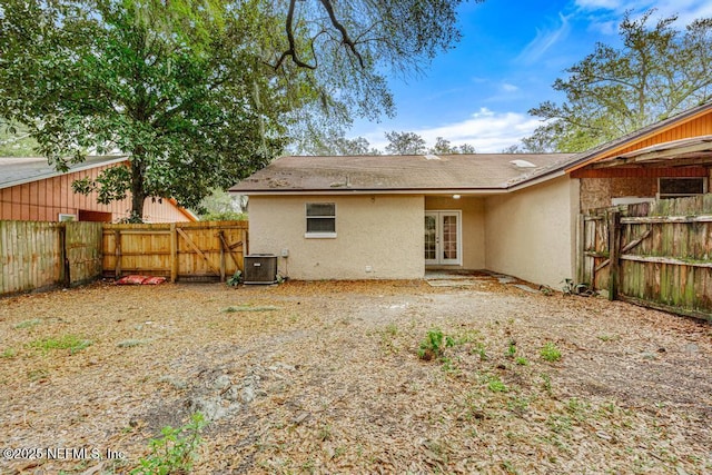 back of house featuring cooling unit, french doors, fence, and stucco siding