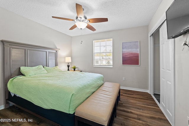 bedroom with a ceiling fan, a textured ceiling, wood finished floors, a closet, and baseboards