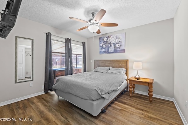 bedroom featuring a ceiling fan, wood finished floors, baseboards, and a textured ceiling