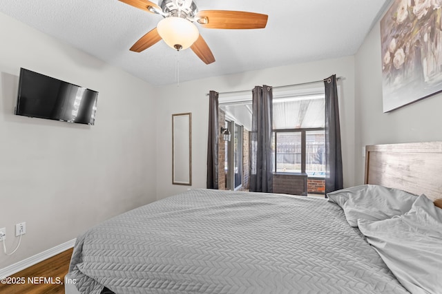 bedroom featuring baseboards, dark wood finished floors, and a ceiling fan