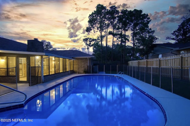 pool at dusk featuring a fenced in pool, a sunroom, and fence