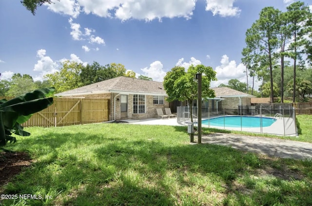 view of swimming pool with a patio, fence, a fenced in pool, and a lawn