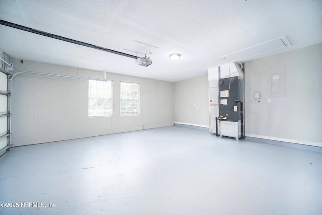 garage featuring baseboards, heating unit, and a garage door opener