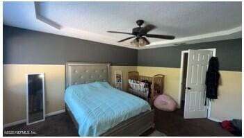 bedroom with a ceiling fan and baseboards