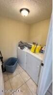 laundry room featuring laundry area, washing machine and dryer, and tile patterned flooring