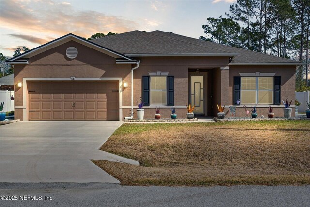 view of front of property featuring a yard and a garage