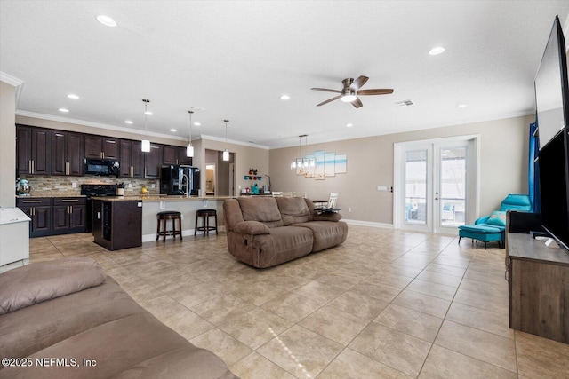 tiled living room with ornamental molding and ceiling fan with notable chandelier