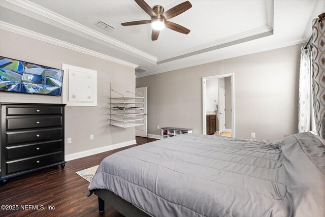 bedroom featuring ensuite bathroom, dark hardwood / wood-style floors, ceiling fan, a tray ceiling, and crown molding