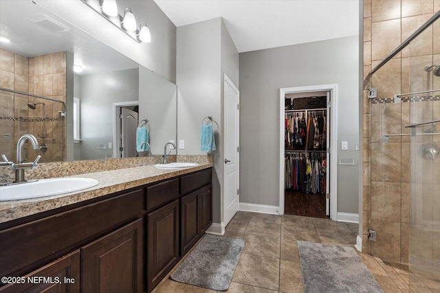 bathroom with walk in shower, vanity, and tile patterned flooring