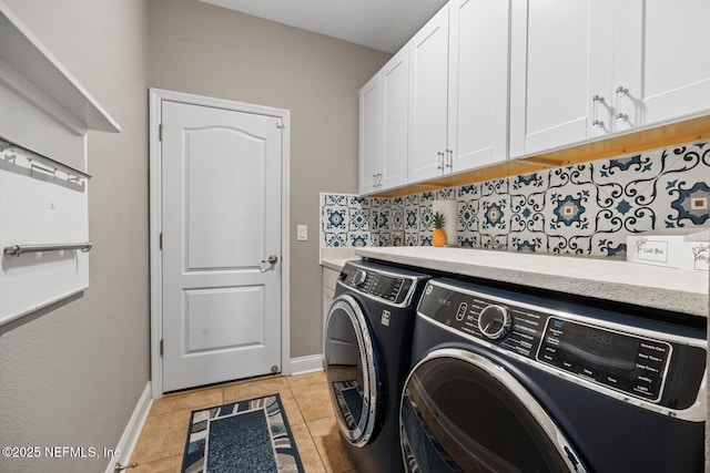 laundry room featuring separate washer and dryer, light tile patterned floors, and cabinets