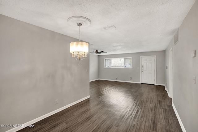 interior space with dark hardwood / wood-style floors, a textured ceiling, and a notable chandelier