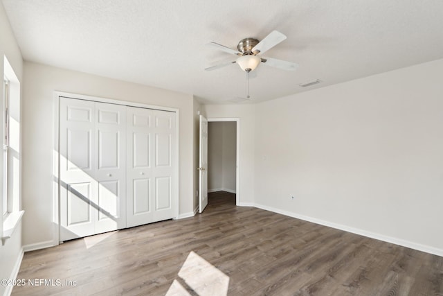 unfurnished bedroom featuring hardwood / wood-style floors, ceiling fan, and a closet