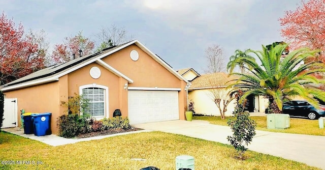 view of front facade featuring an attached garage, a front yard, concrete driveway, and stucco siding