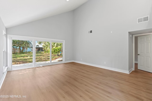 spare room featuring light hardwood / wood-style flooring and high vaulted ceiling