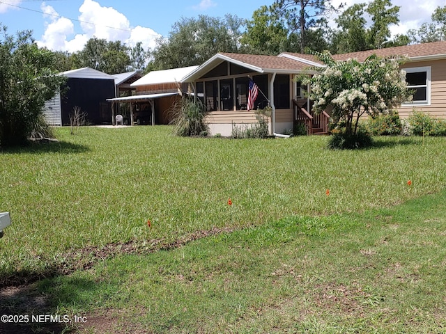 view of front facade with a sunroom, a front lawn, and a carport