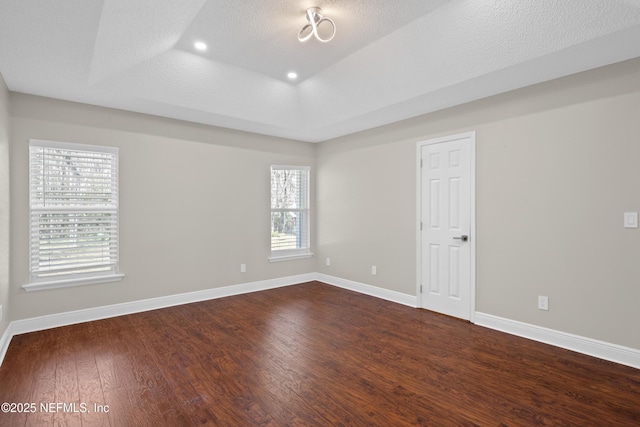 unfurnished room with hardwood / wood-style flooring and a textured ceiling