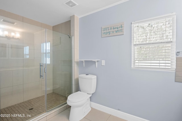 bathroom featuring tile patterned floors, toilet, and a shower with door