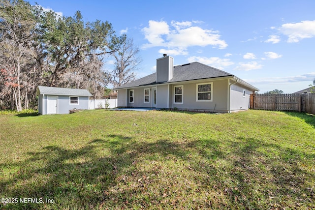 back of property with a storage shed and a yard