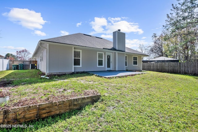 rear view of property with a lawn and a patio