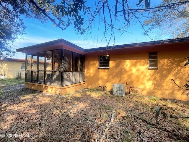 view of property exterior with cooling unit and a sunroom