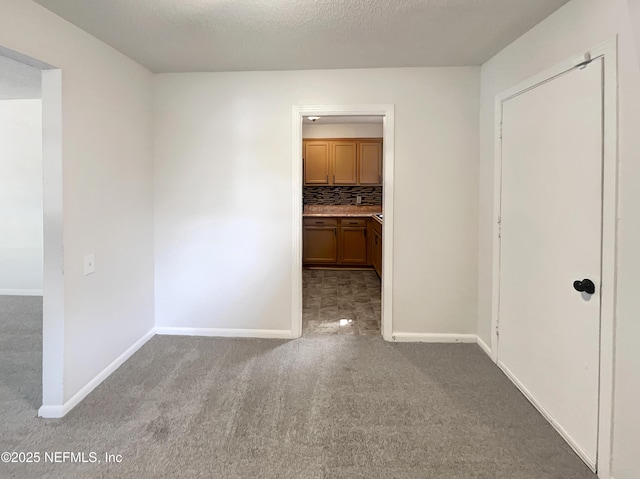 empty room featuring light carpet and a textured ceiling