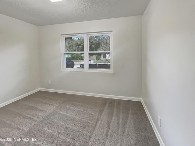 carpeted empty room featuring a textured ceiling