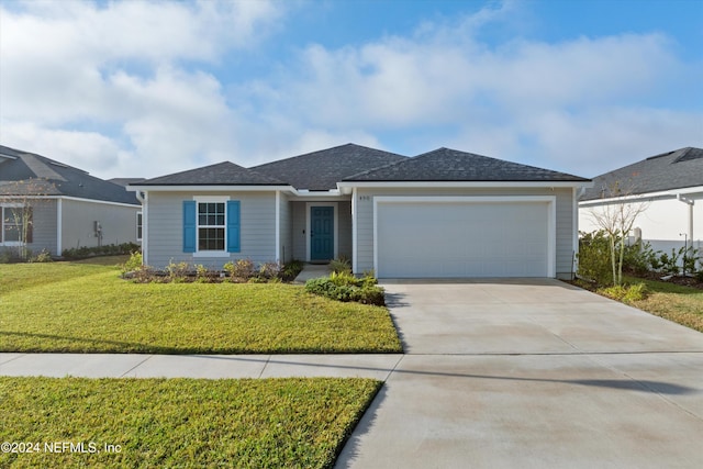 view of front of property featuring a garage and a front lawn