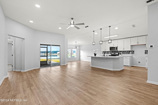 kitchen with ceiling fan, appliances with stainless steel finishes, a kitchen island with sink, white cabinetry, and decorative light fixtures