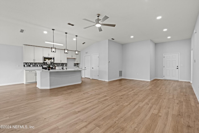 unfurnished living room featuring ceiling fan, lofted ceiling, and light wood-type flooring