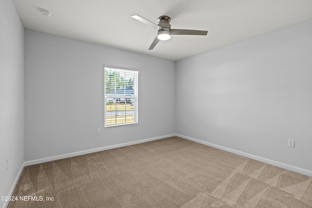 unfurnished room with ceiling fan and carpet flooring