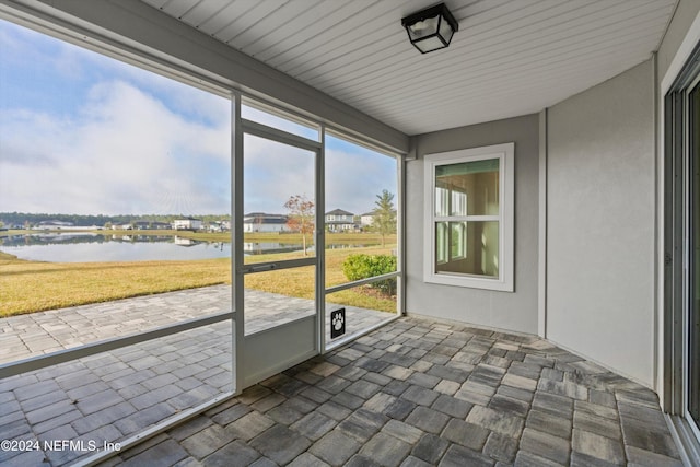 unfurnished sunroom featuring a water view and a wealth of natural light