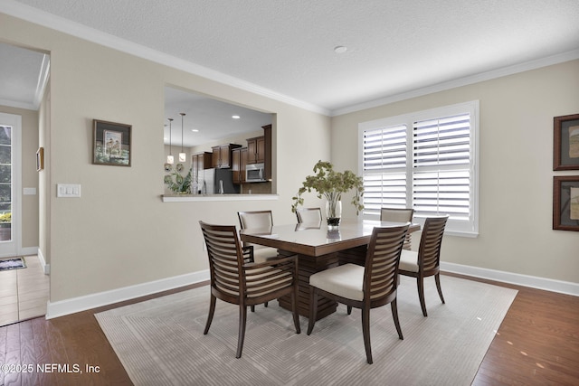 dining area featuring crown molding, a textured ceiling, and dark hardwood / wood-style flooring