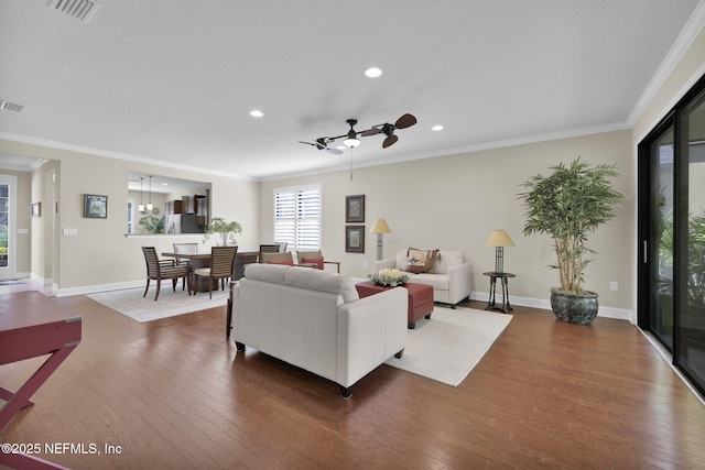 living room with hardwood / wood-style flooring, ornamental molding, and ceiling fan