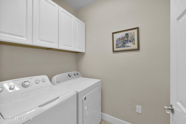 washroom featuring washer and clothes dryer and cabinets