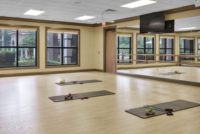 exercise room featuring ornamental molding, a paneled ceiling, hardwood / wood-style floors, and ceiling fan