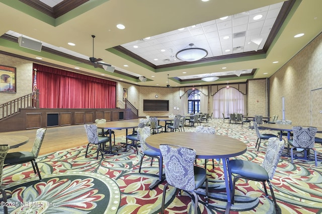 dining area featuring crown molding, a tray ceiling, and light wood-type flooring