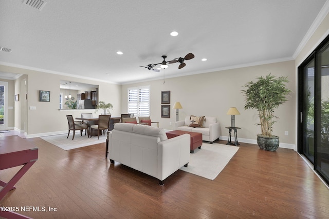 living room featuring hardwood / wood-style floors, crown molding, and ceiling fan