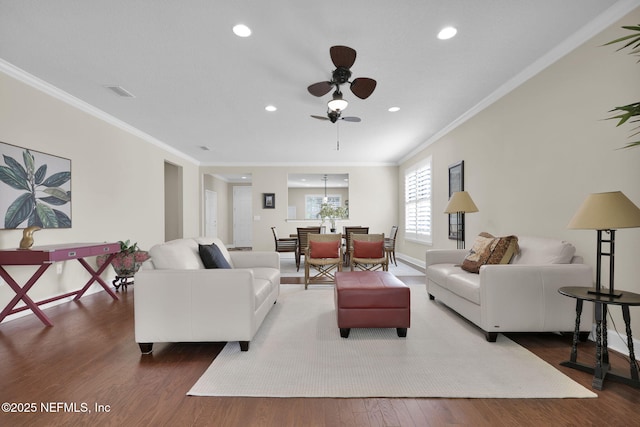 living room with dark hardwood / wood-style flooring, crown molding, and ceiling fan