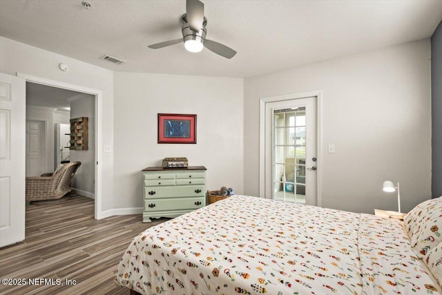 bedroom with ceiling fan, dark hardwood / wood-style flooring, and a textured ceiling