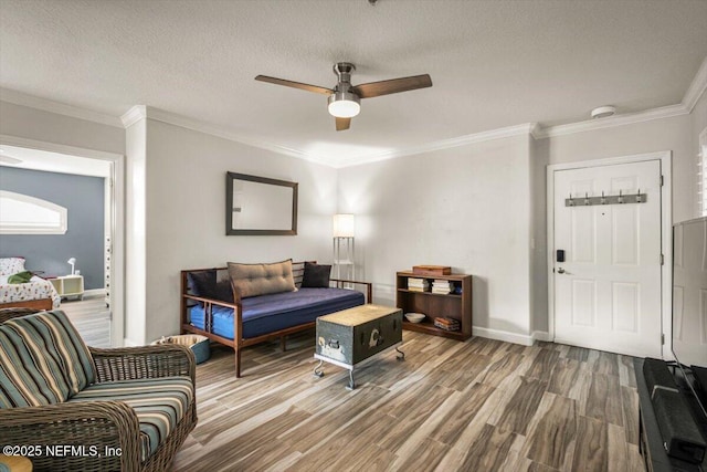 living room featuring crown molding, hardwood / wood-style floors, ceiling fan, and a textured ceiling