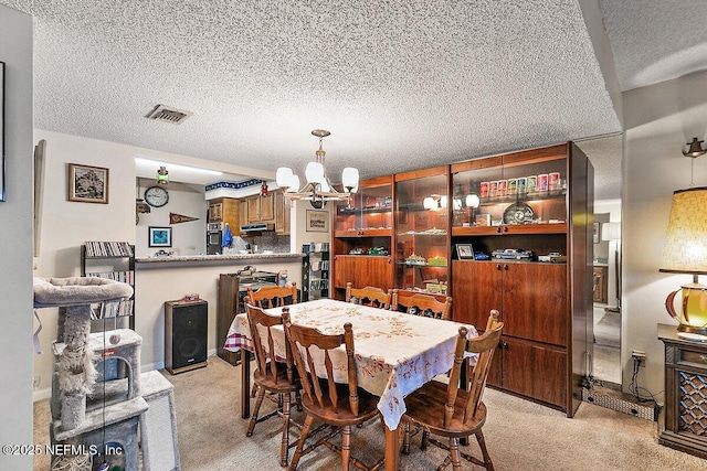 dining area with light carpet, a textured ceiling, and a notable chandelier