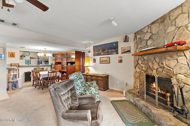 carpeted living room with a fireplace, ceiling fan, and a textured ceiling