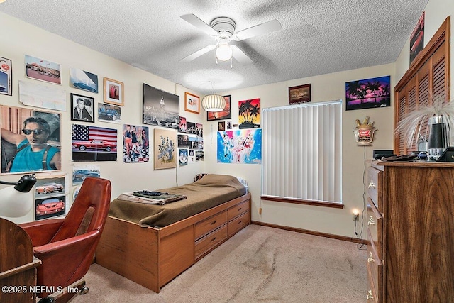 bedroom featuring ceiling fan, light carpet, and a textured ceiling