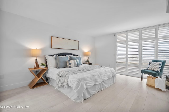 bedroom with access to exterior and light hardwood / wood-style floors