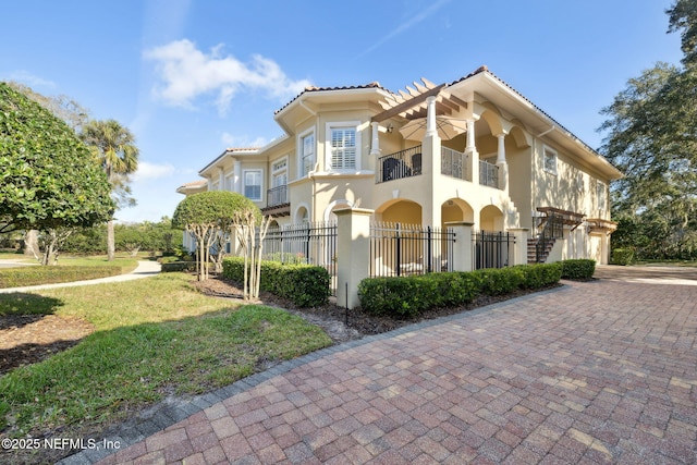 view of front of house with a front lawn and a balcony