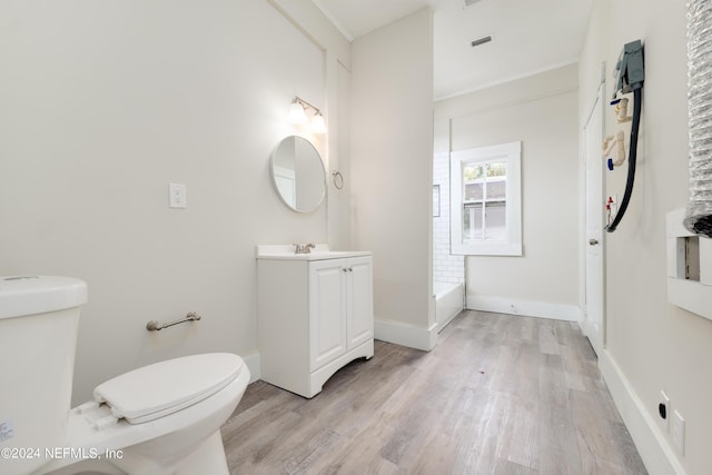 bathroom with hardwood / wood-style flooring, ornamental molding, vanity, and toilet