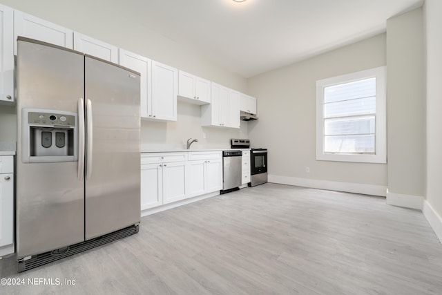 kitchen featuring stainless steel appliances, white cabinetry, sink, and light wood-type flooring