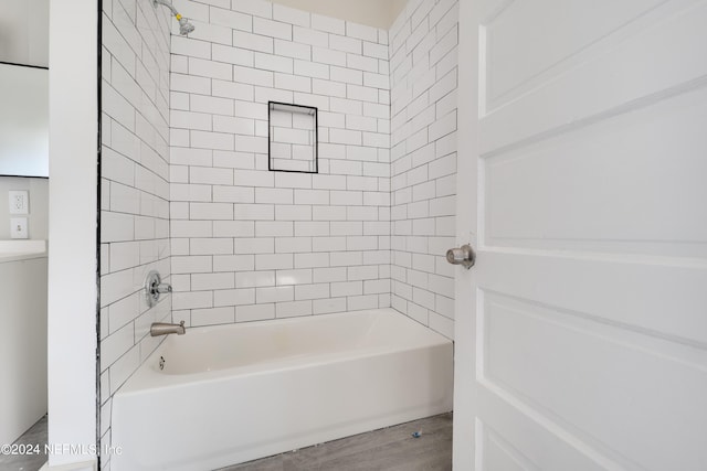 bathroom with tiled shower / bath and wood-type flooring